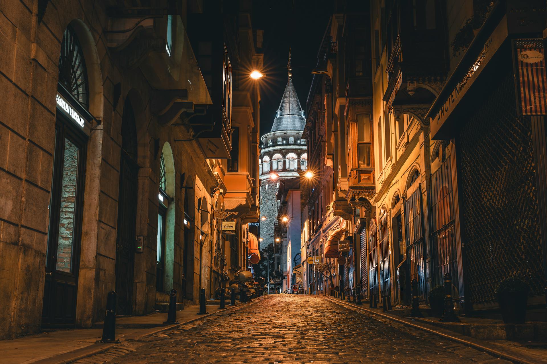 Illuminated Galata Tower seen from a narrow street at night in Istanbul – Conmigo Travel Agency