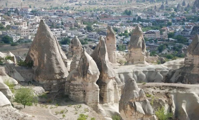 Fairy chimney rock formations with town in background, Cappadocia