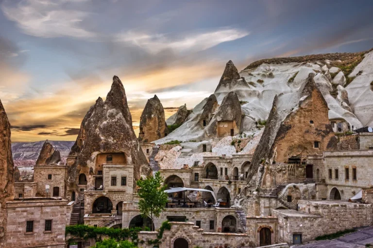 Cave hotels carved into rock at sunset in Goreme, Cappadocia