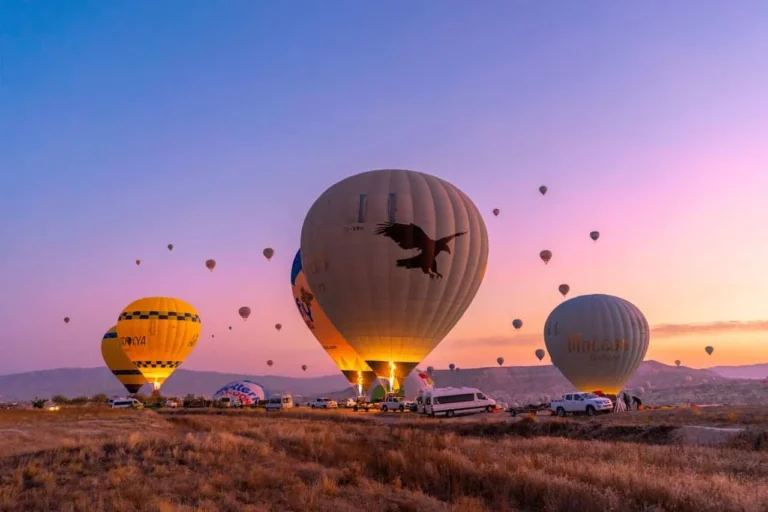 Hot air balloons taking off at sunrise over the Cappadocia valley in Turkey.