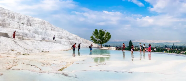 Visitors walking up the white travertine hill at Pamukkale