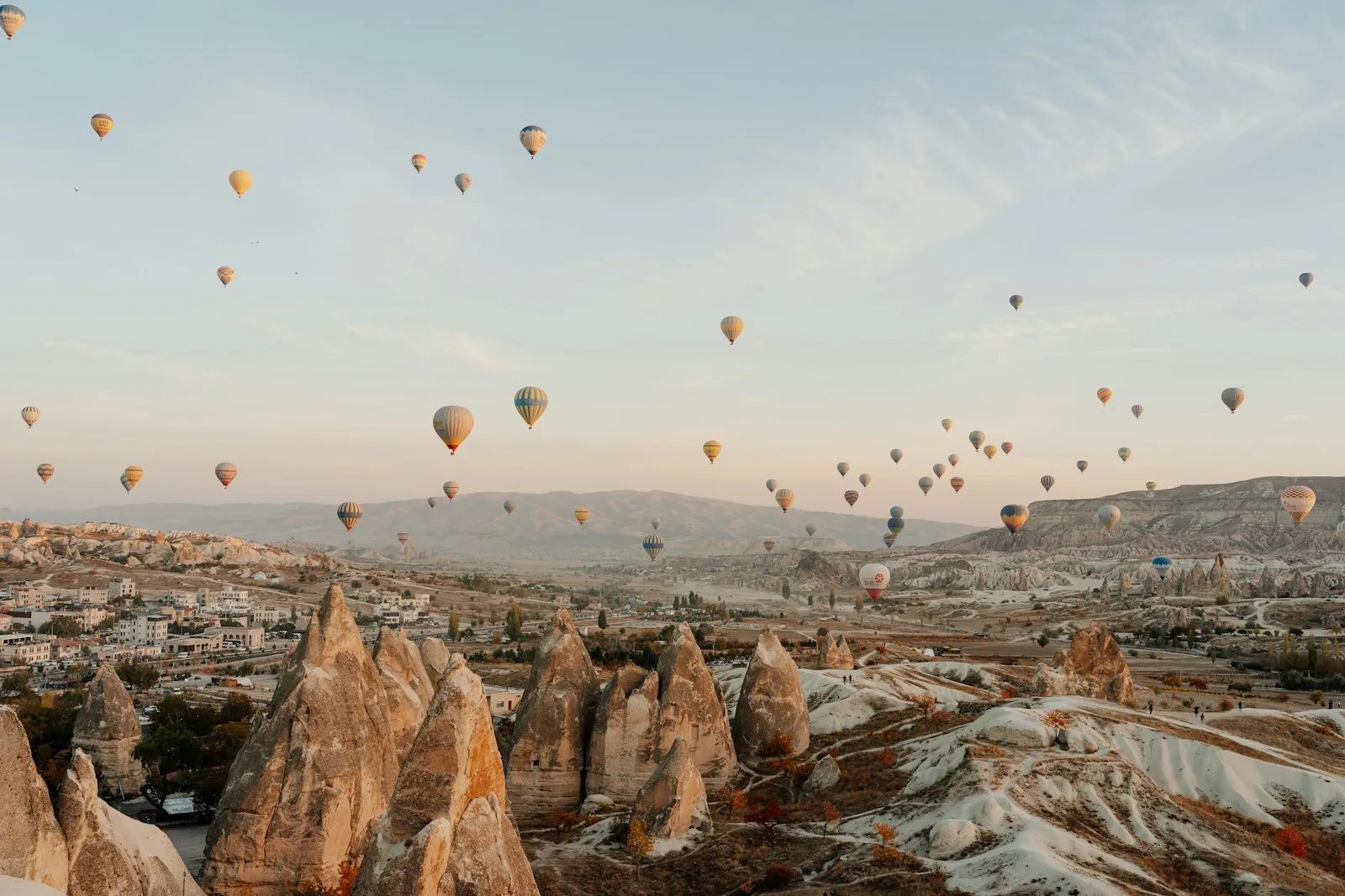 Hot air balloons rising over the fairy chimneys of Cappadocia at sunrise