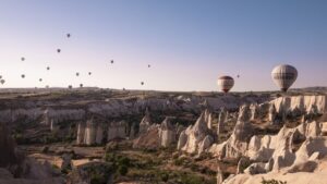 Hot air balloons over Cappadocia fairy chimneys at sunrise