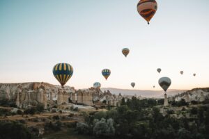 Colorful hot air balloons above Cappadocia landscape at sunrise