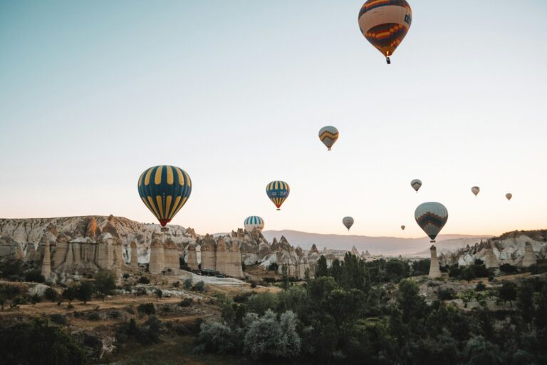 Colorful hot air balloons above Cappadocia landscape at sunrise