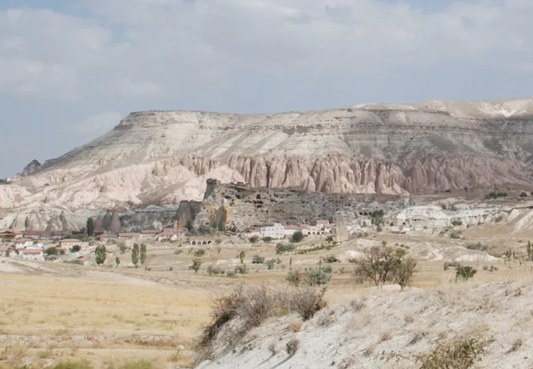 The abandoned cliff face of old Çavuşin village in Cappadocia with cave dwelling openings visible across the rock