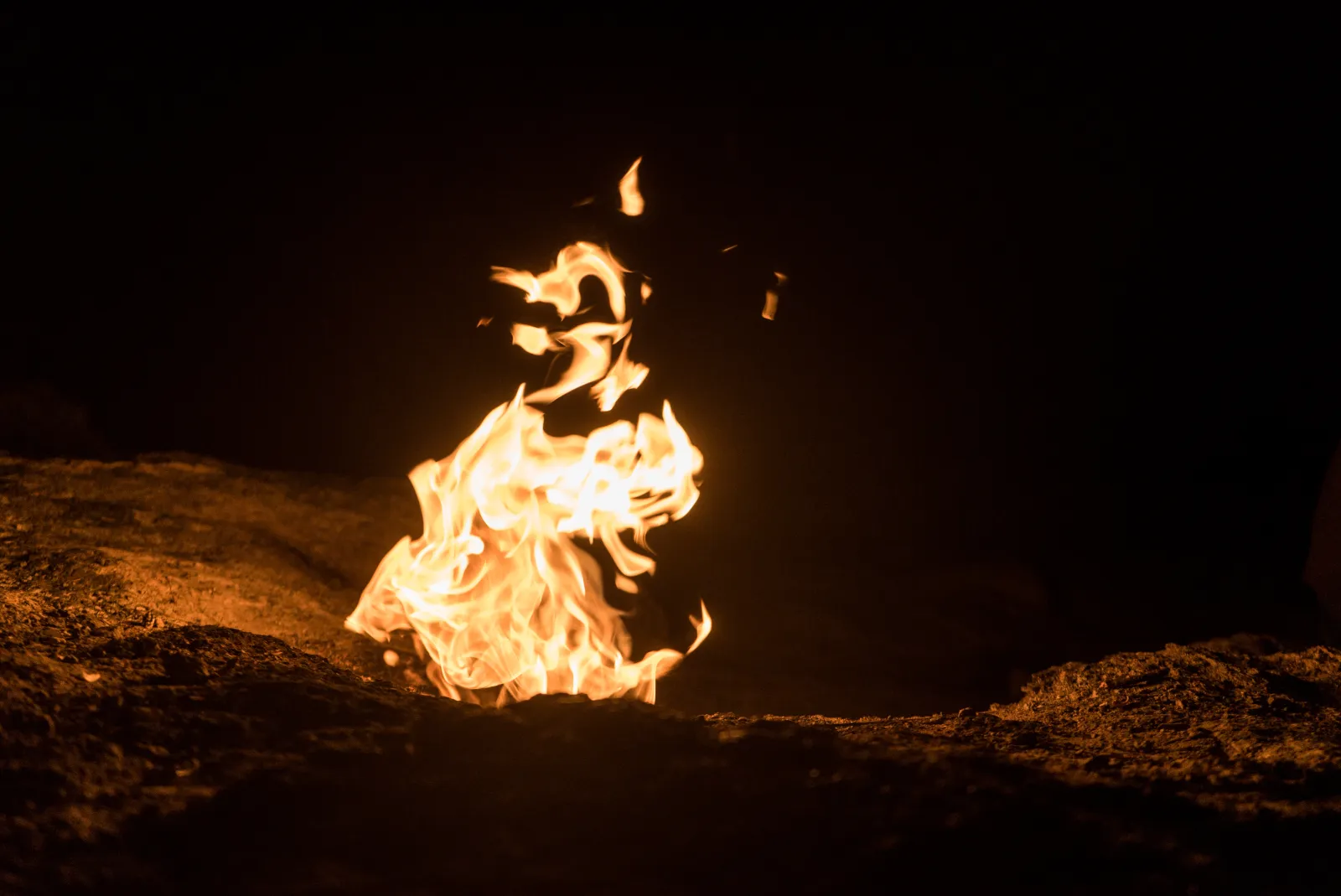Natural gas flames burning from rock fissures at Chimaera Yanartas at night near Olympos