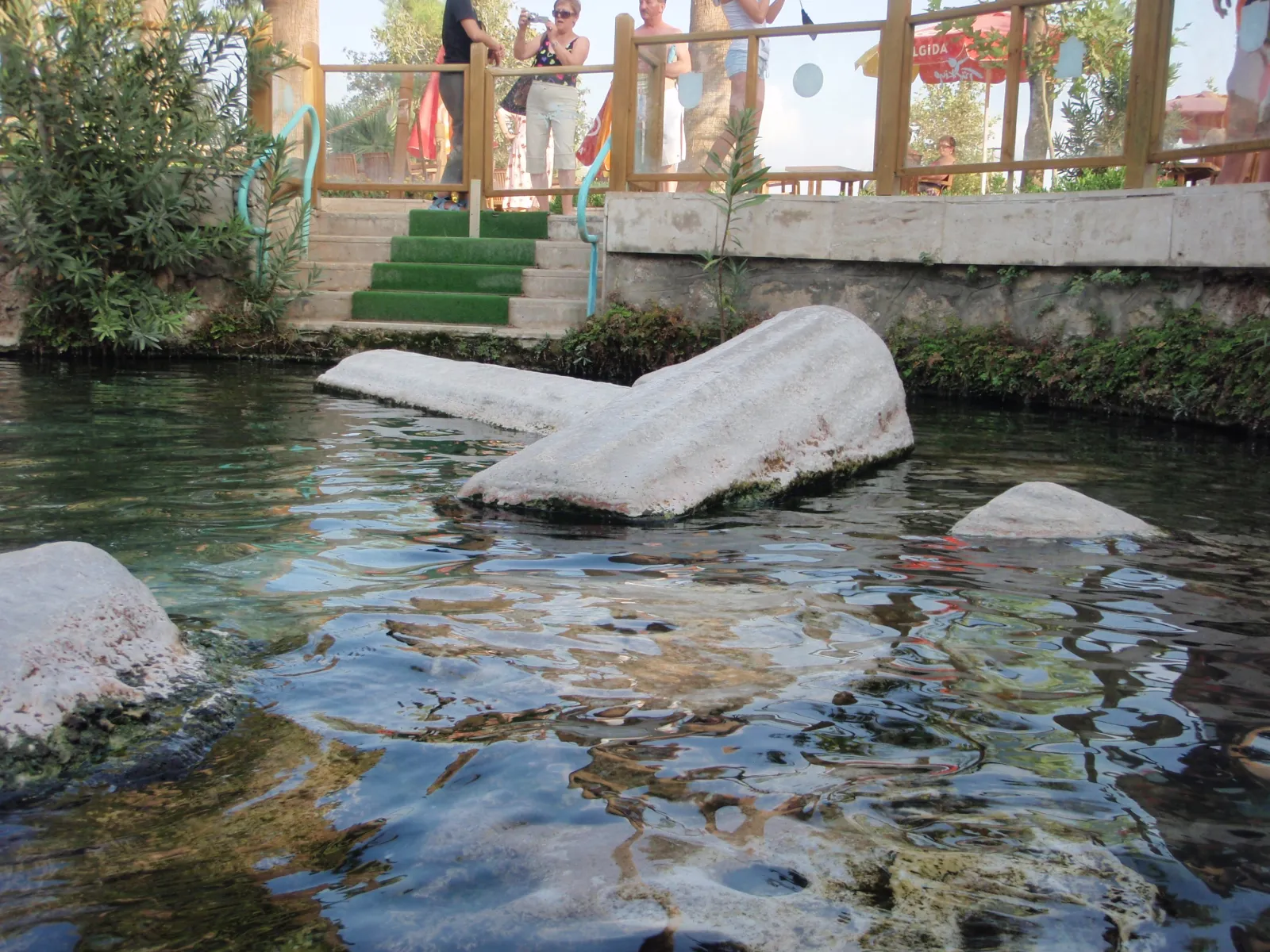 Turquoise thermal water of Cleopatra's Pool with submerged Roman columns visible beneath the surface