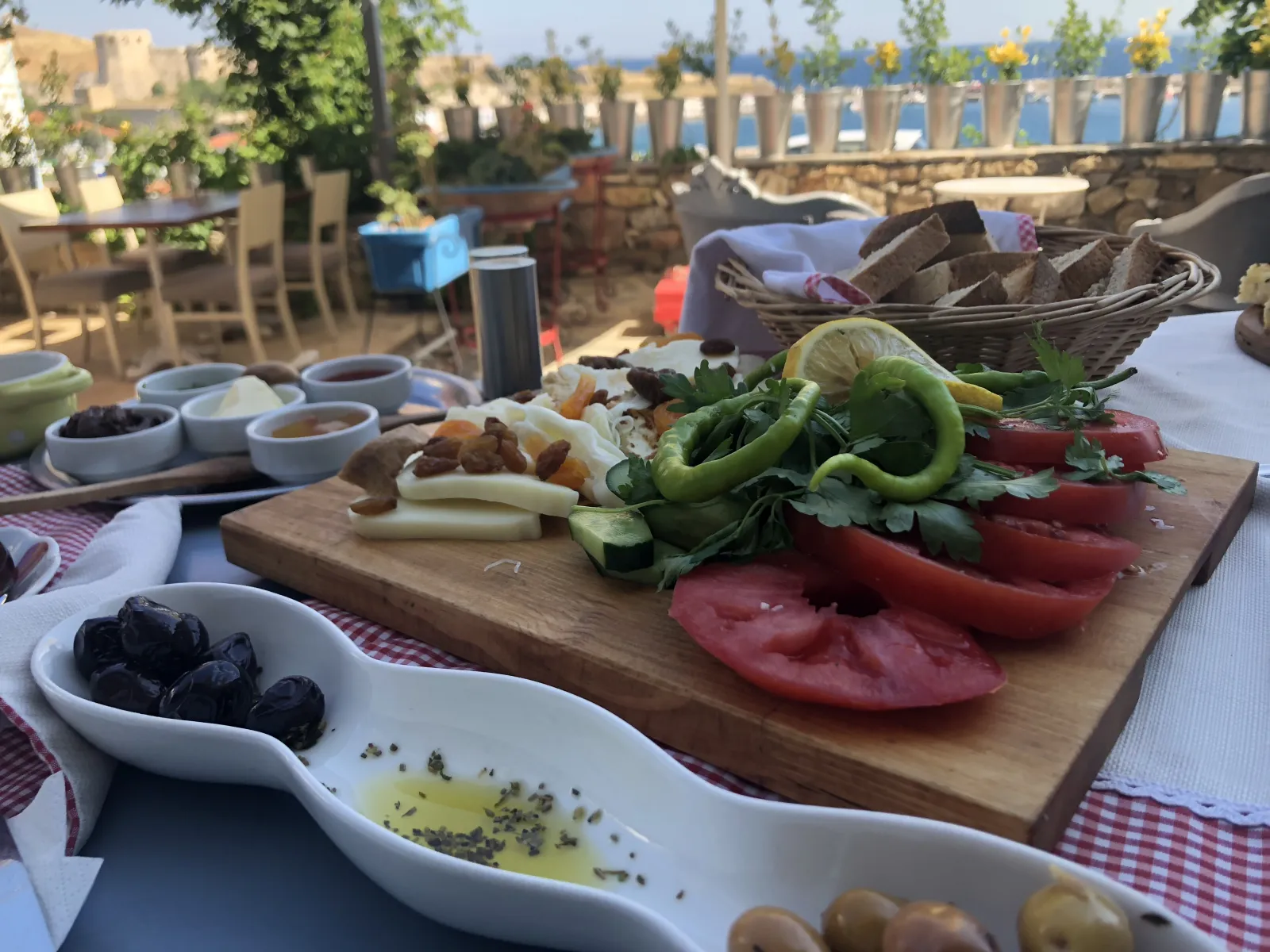 Traditional village breakfast spread with olives, cheese, bread, and fresh vegetables on a rustic table