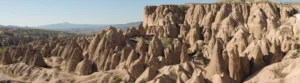 The wide landscape of Devrent Valley in Cappadocia with eroded tuff formations across the field