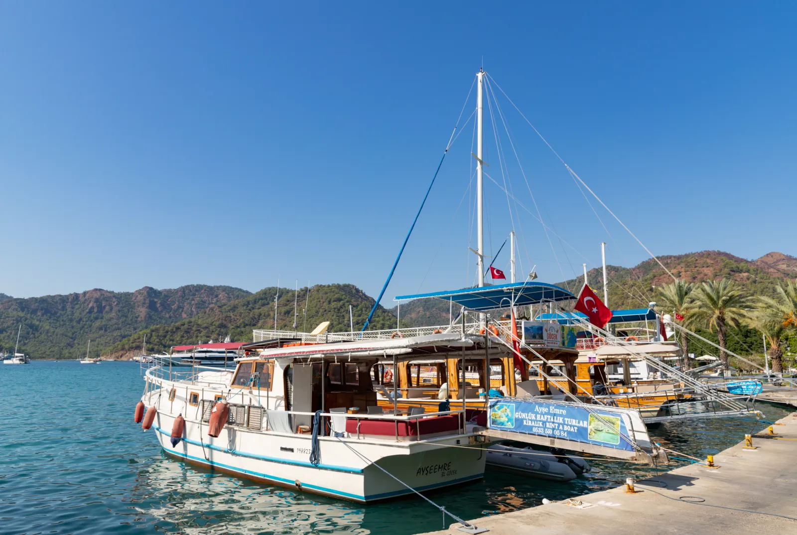 A traditional wooden gulet boat with Turkish flag docked in Gocek harbor ready for the 12 Islands tour