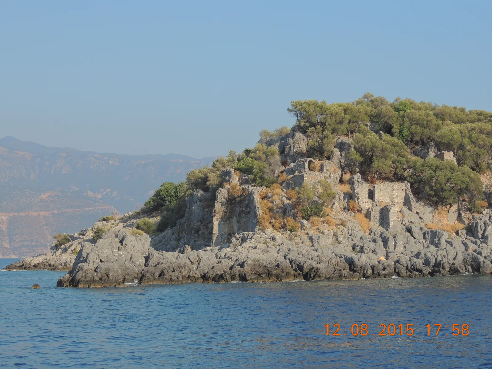Remains of a Byzantine church on Gemiler Island with stone walls and arched doorway overlooking the Mediterranean