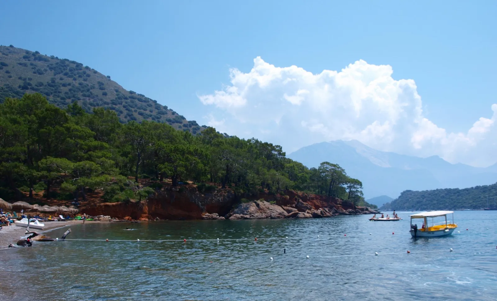 Sunset behind Gemiler Island silhouette seen from a boat with orange sky reflected on the Mediterranean water