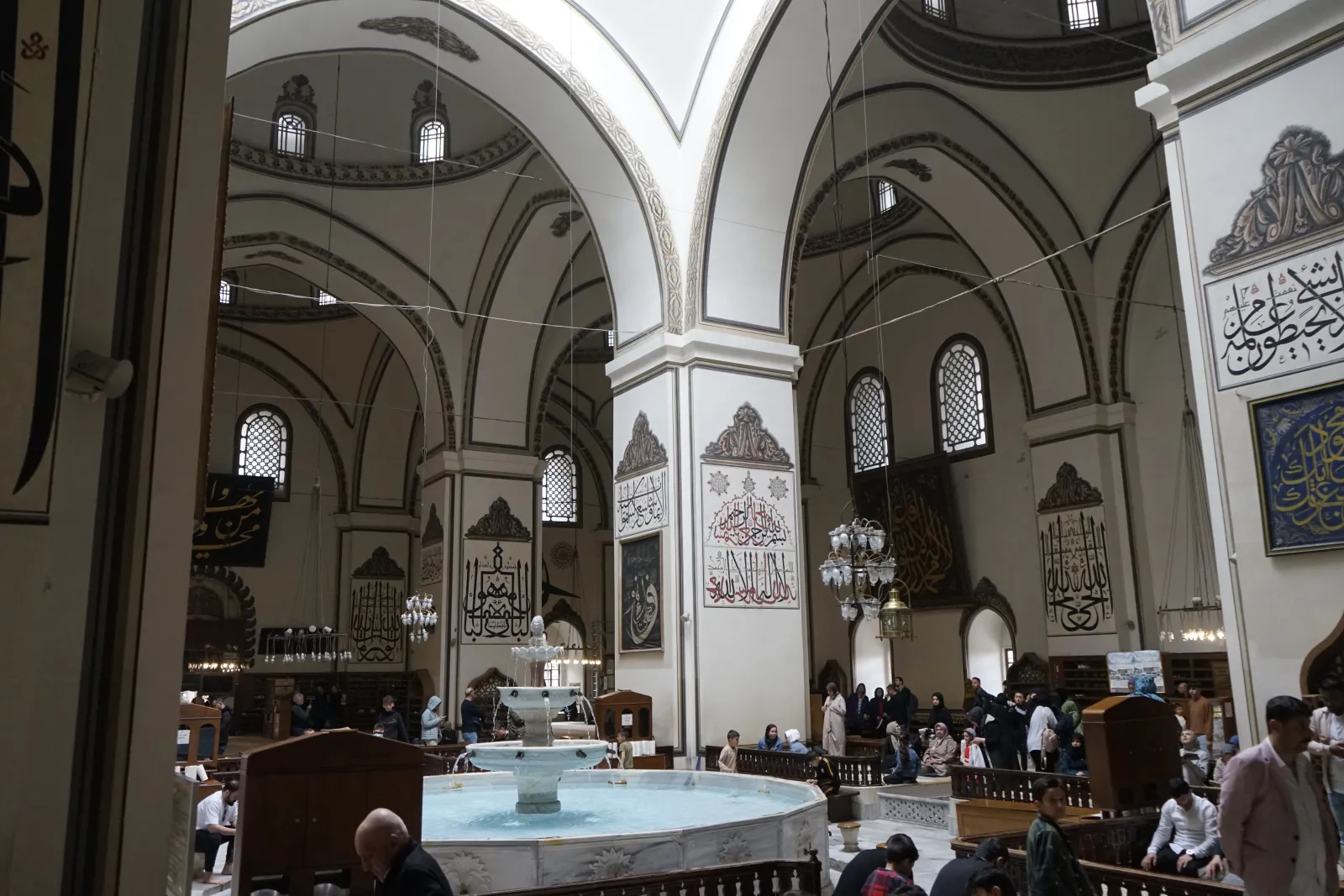 The indoor şadırvan fountain at the center of the Grand Mosque Bursa with light falling from the oculus above
