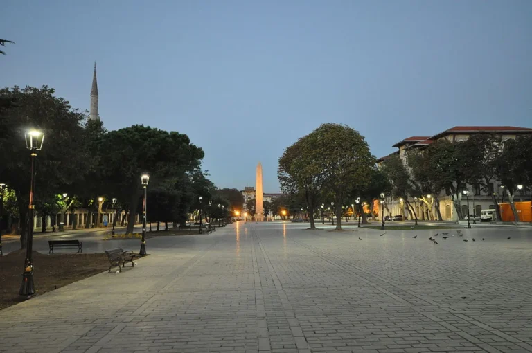The Obelisk of Theodosius standing in Sultanahmet Square at dusk with a minaret in the background