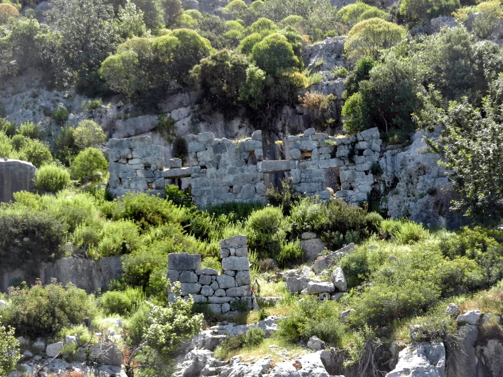 Tour boat passing over the Kekova sunken city with submerged walls visible in the clear water