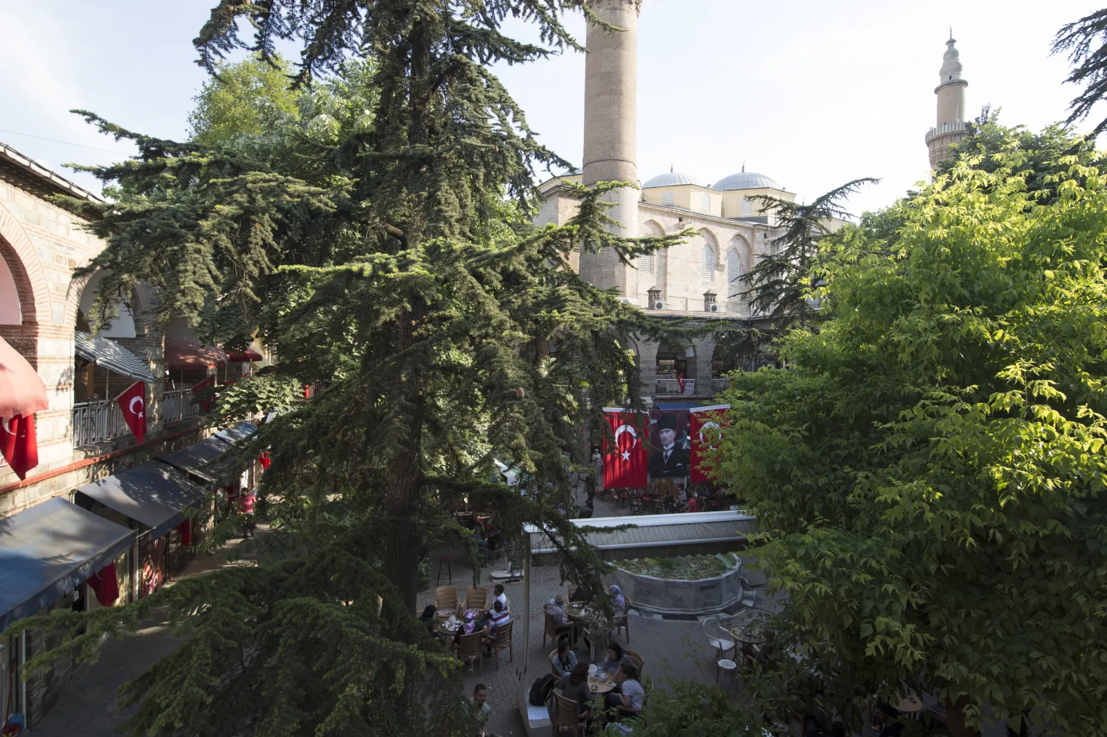 Two-story arcaded gallery inside Koza Han Bursa with stone arches and wooden doors to silk shops