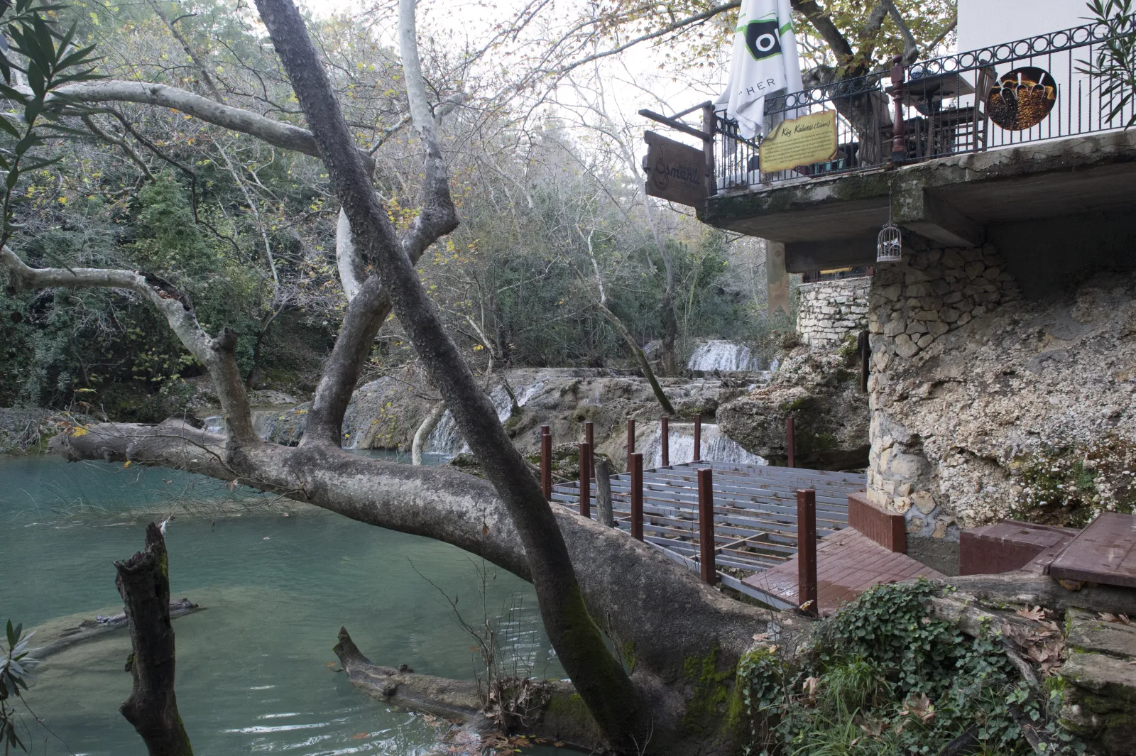 Walking trail along the stream at Kursunlu Nature Park with natural pools and travertine formations