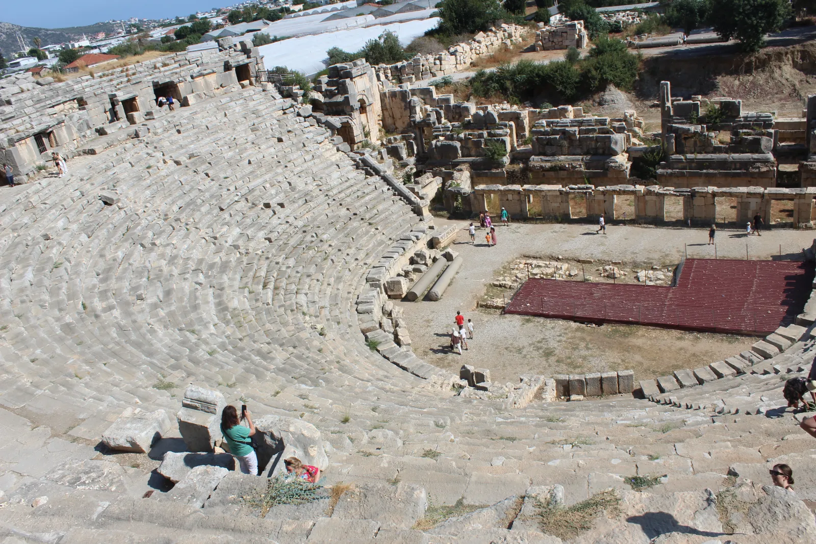 The Roman theater at ancient Myra with rows of Lycian rock tombs visible on the cliff face behind the stage
