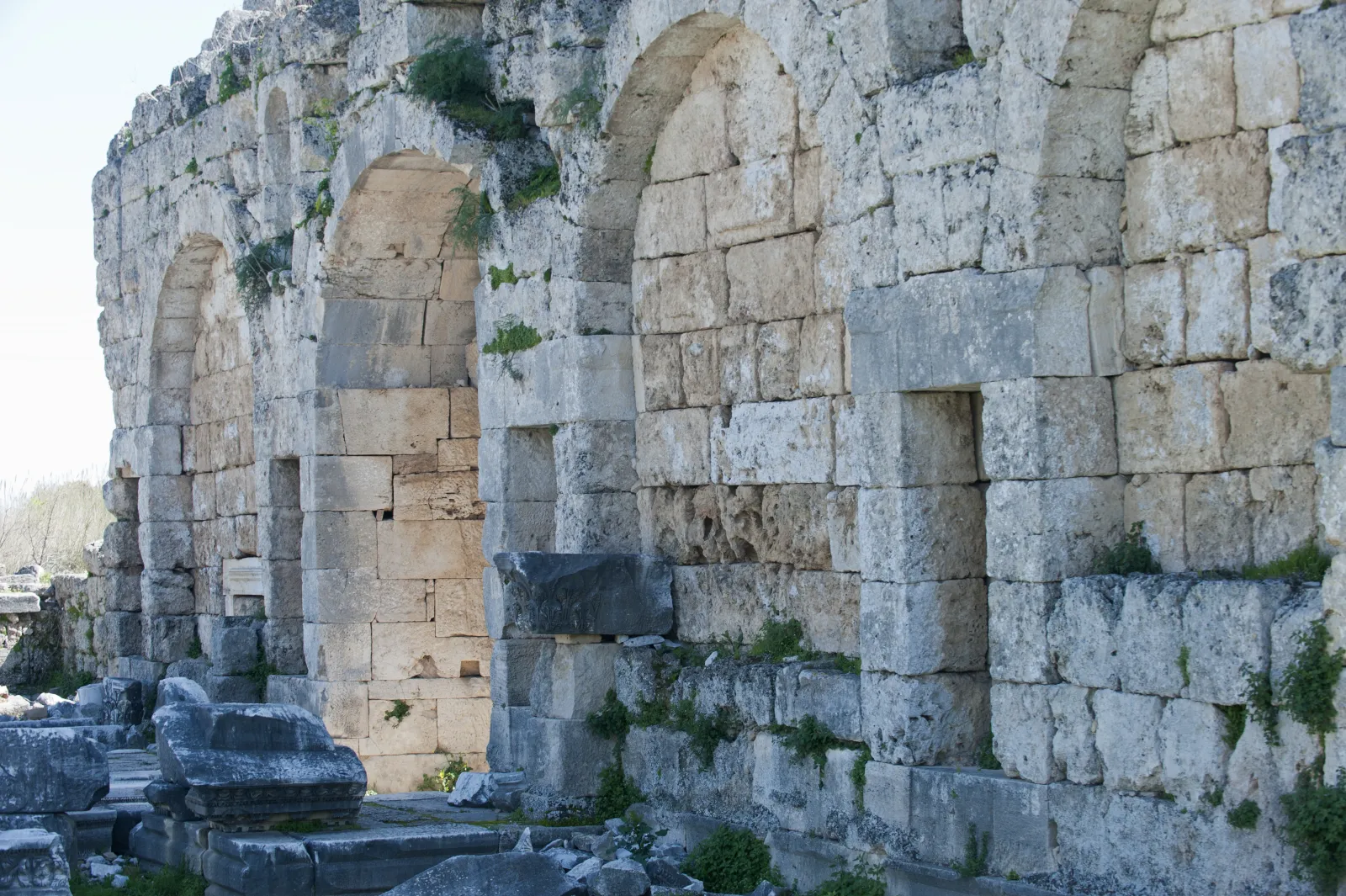 The Roman gate and towers at Perge ancient city with stone walls rising above the plain