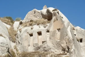 Carved dovecotes in the cliff faces of Pigeon Valley Cappadocia with the valley dropping away toward Goreme