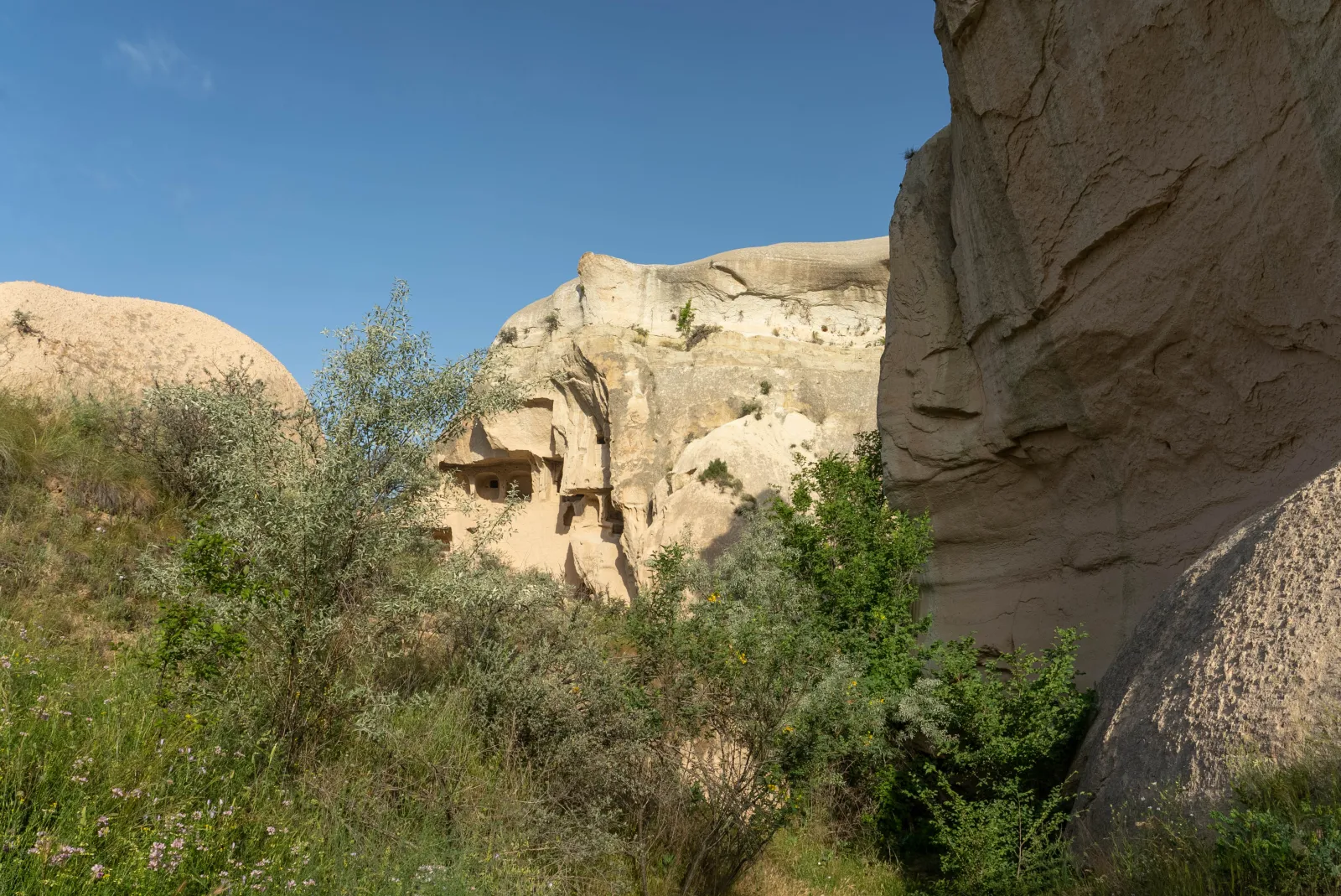 A rock-cut church hidden in the cliffs of Red Valley Cappadocia with carved cave openings