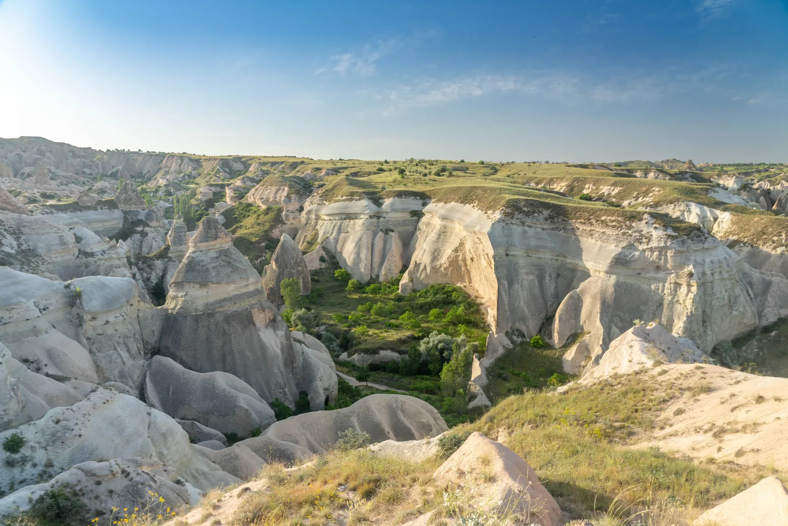 Hikers walking through the red-tinted rock formations of Red Valley in Cappadocia