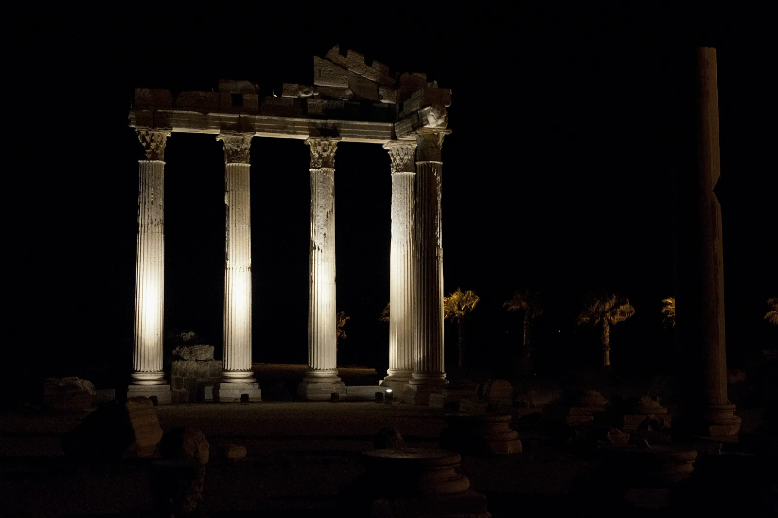 The Temple of Apollo at Side illuminated at night against the dark Mediterranean