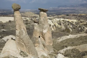 The Three Beauties fairy chimneys near Urgup in Cappadocia — three capped tuff columns standing side by side
