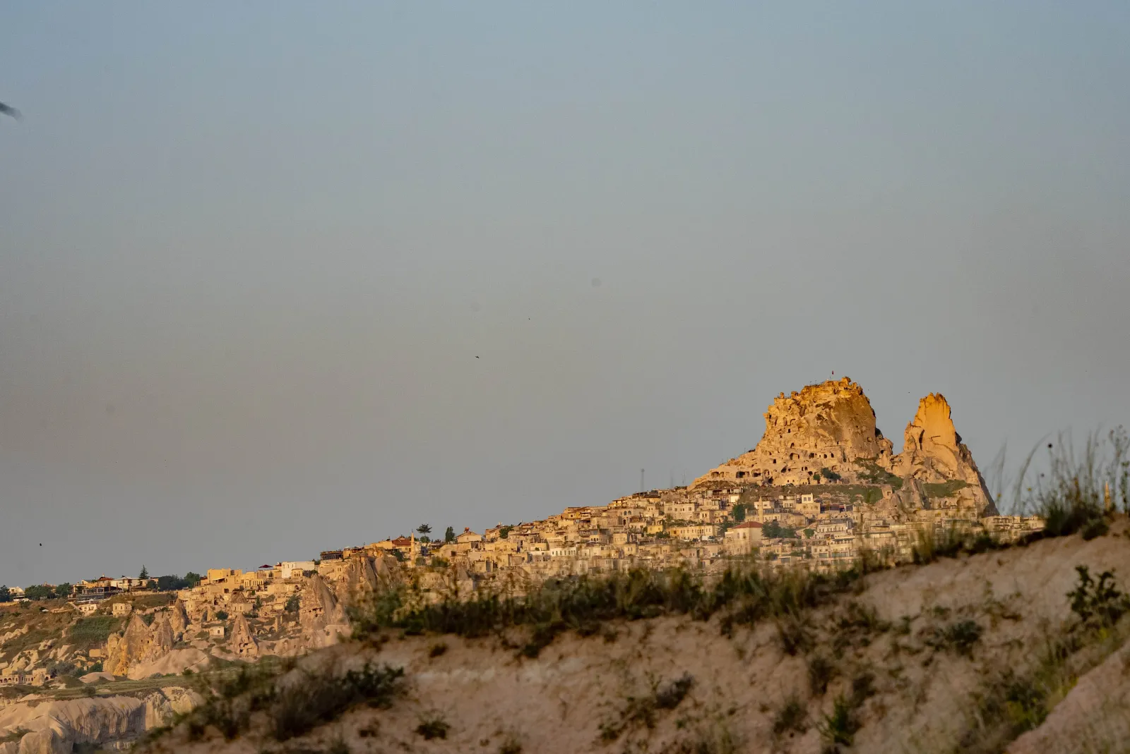Uchisar Castle at sunset seen from the valley below in Cappadocia