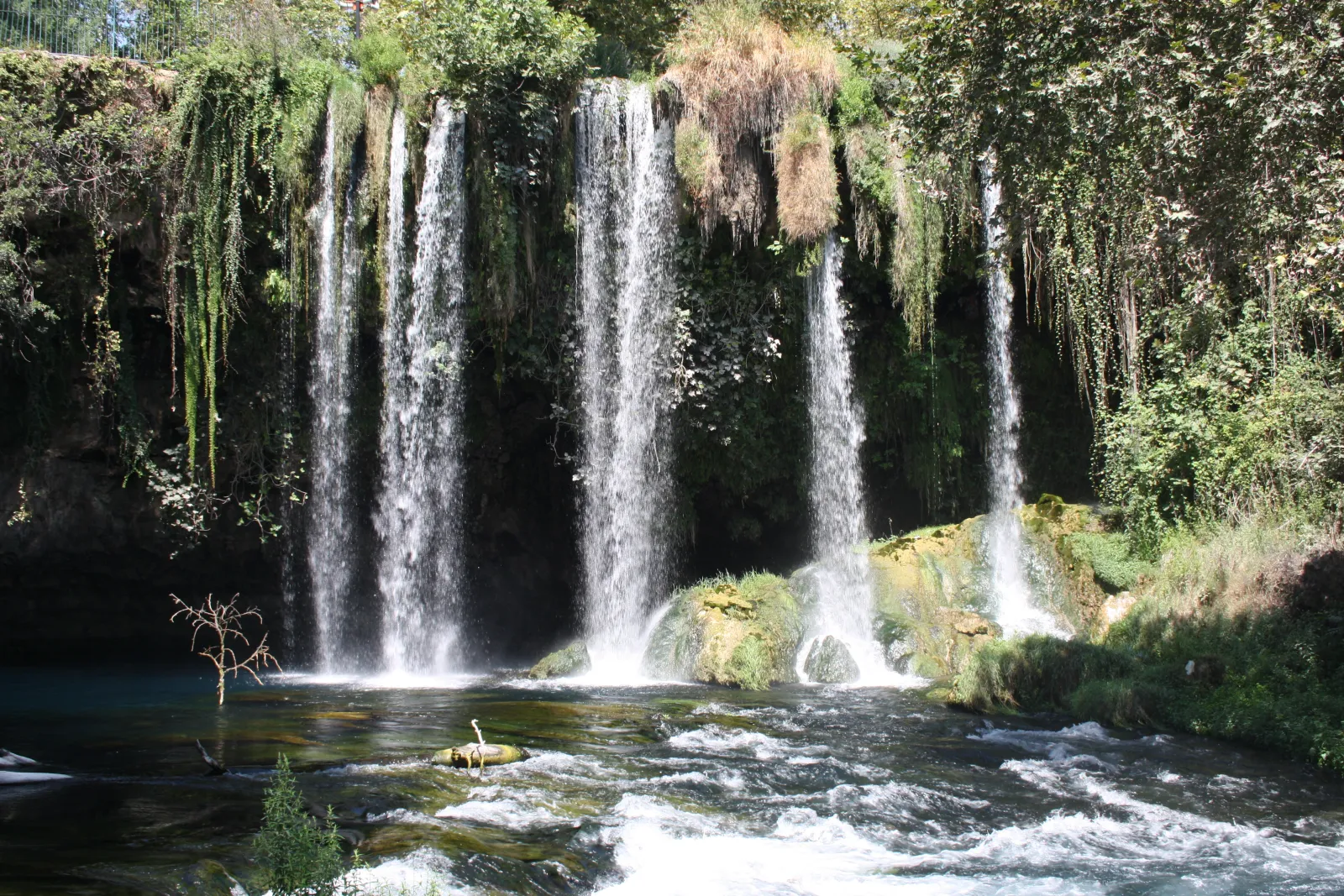 Upper Düden Waterfall cascading into a gorge surrounded by green trees in the park setting
