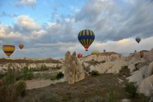 Hot-air balloons rising at sunrise over Cappadocia fairy chimneys in spring
