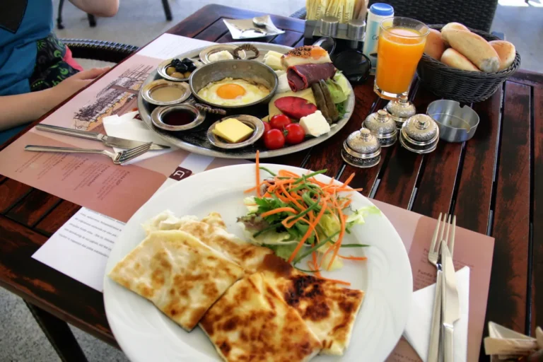 A full Turkish breakfast spread with cheeses, olives, tomatoes, honey, eggs, and tea